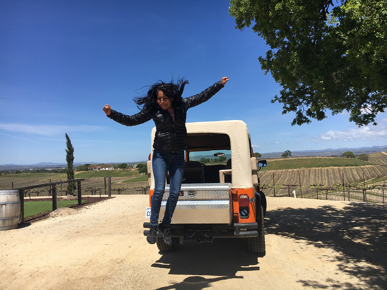 woman jumping out of the back of the wine tour jeep